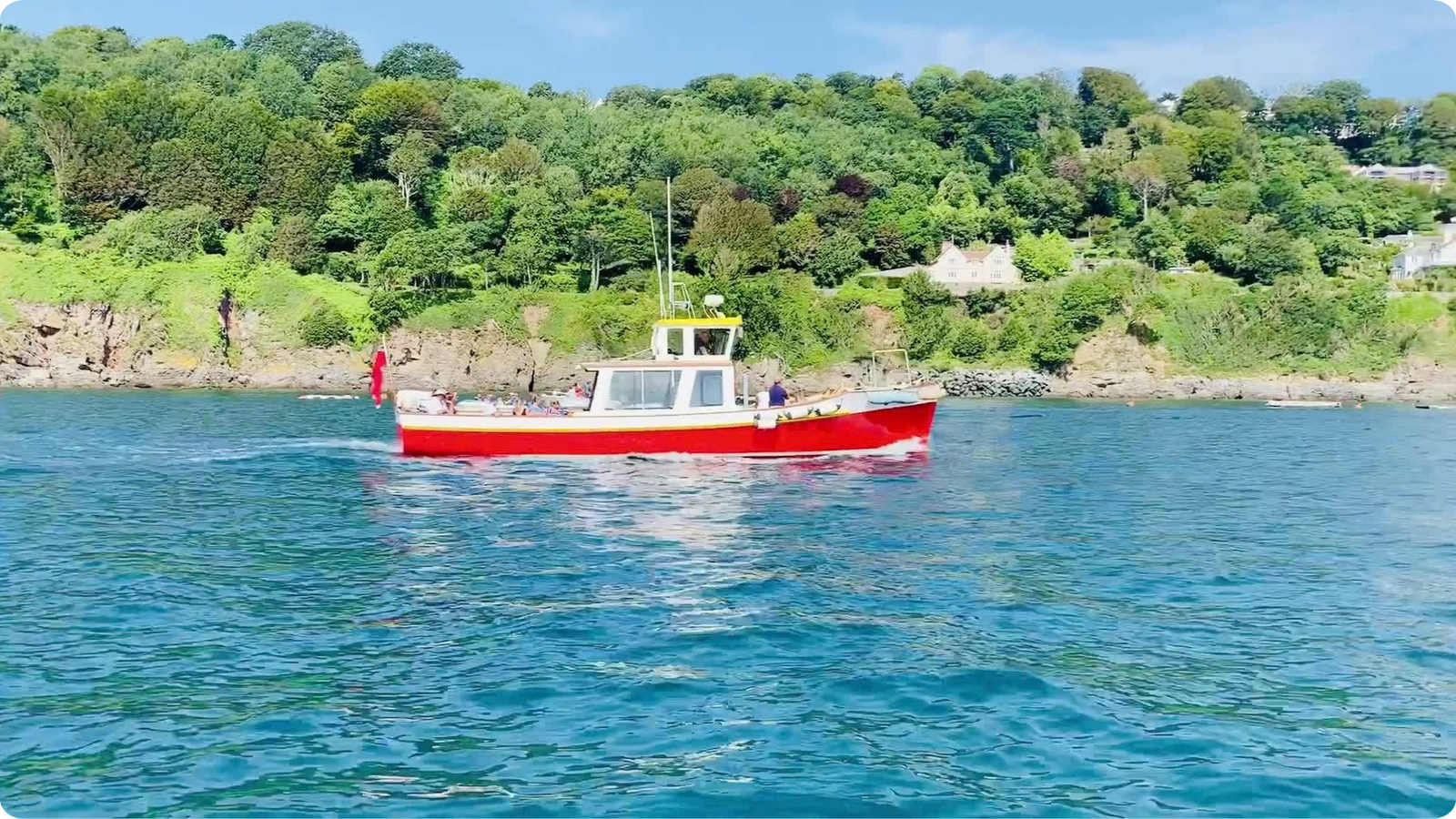 Red passenger boat cruising across the Salcombe estuary