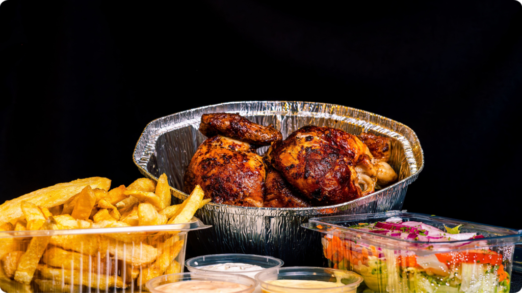 Roast chicken, chips and salad prepared as a takeaway meal