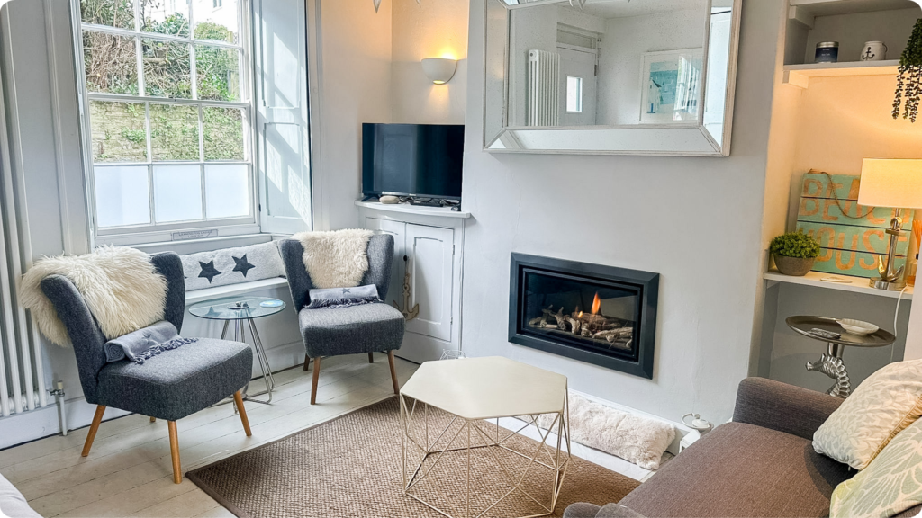 Bright holiday cottage sitting room with a lit fire